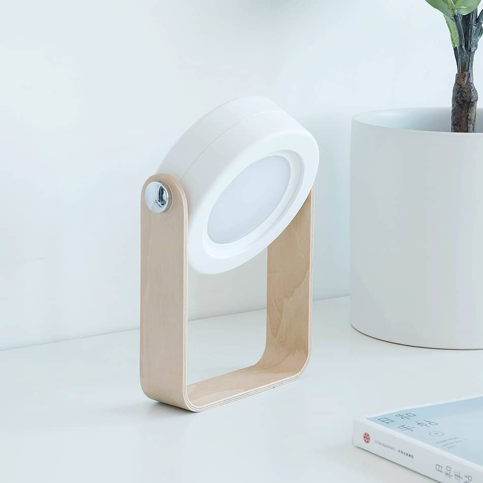 Compact desk lamp with adjustable brightness in white and wood for modern home office