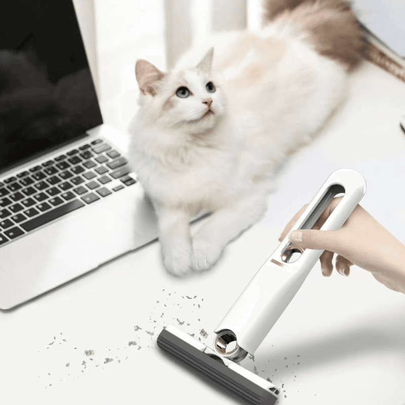 Giggly Gear white compact desk cleaning tool used to clean debris near laptop and cat