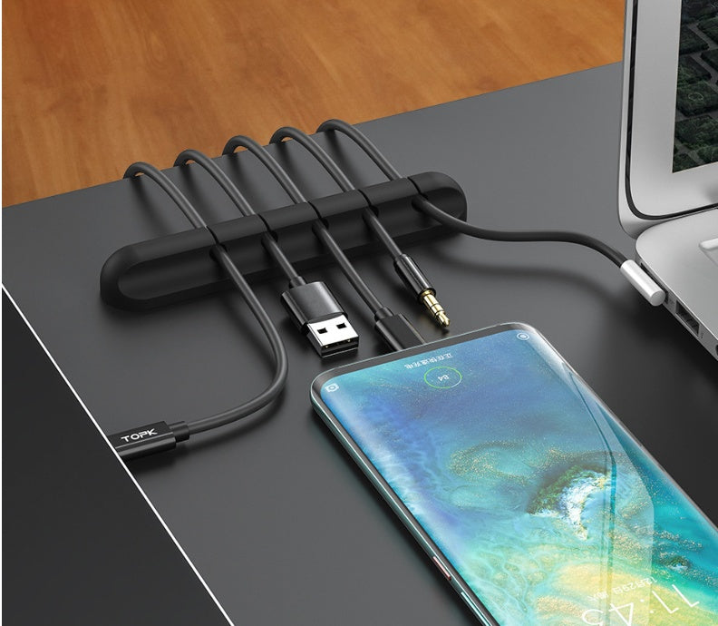 Giggly Gear black desk cable organiser holding multiple cables on a modern office desk